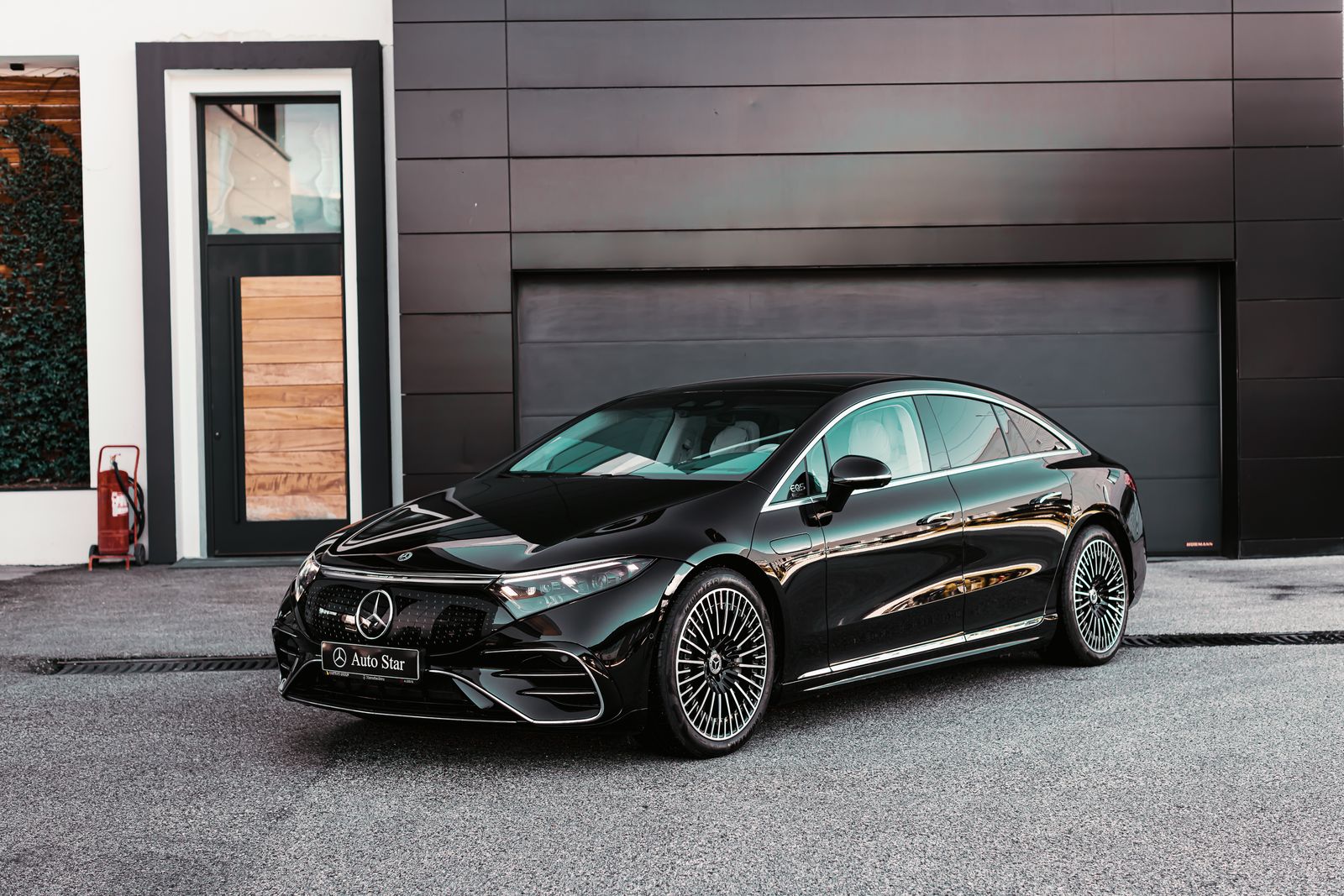 Black Mercedes-Benz saloon in front of a modern building